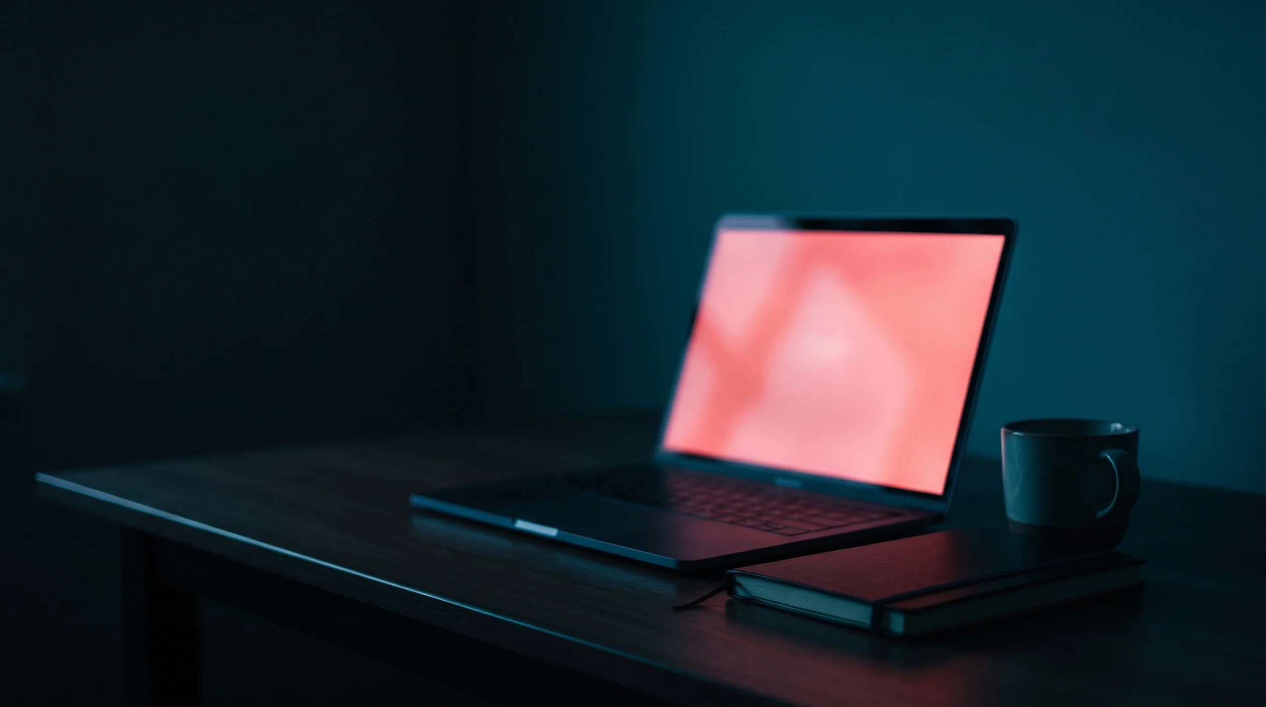 Laptop screen glowing red in a dark office representing a WordPress HTTP 500 error